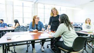 students interact with professor in classroom